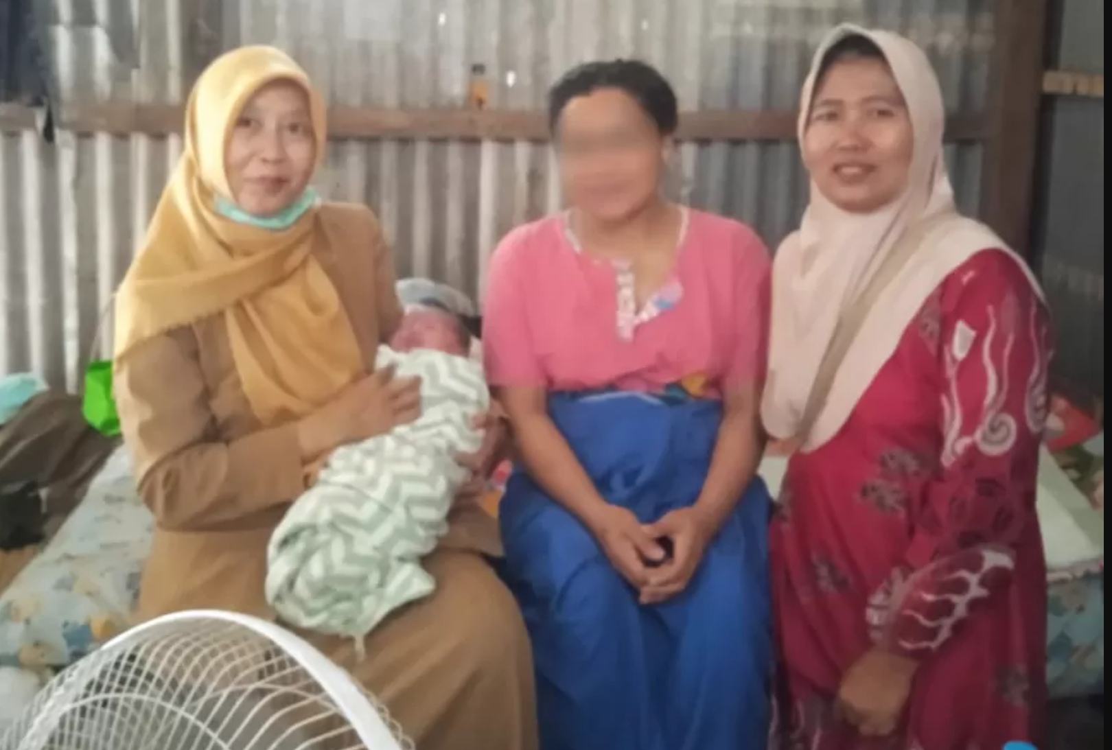 AHN (tengah), ibu yang melahirkan di warung pinggir jalan di Desa Banjarsari, Cerme, Gresik, Selasa (10/2).