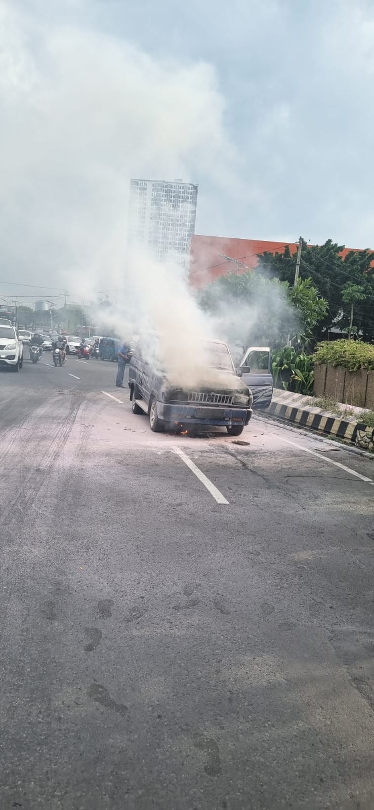 Mobil Kijang&nbsp;milik warga Sragen yang hendak ke Bangkalan terbakar di Bundaran Taman Pelangi, Gayungan Surabaya, Jumat (13/2) sore.