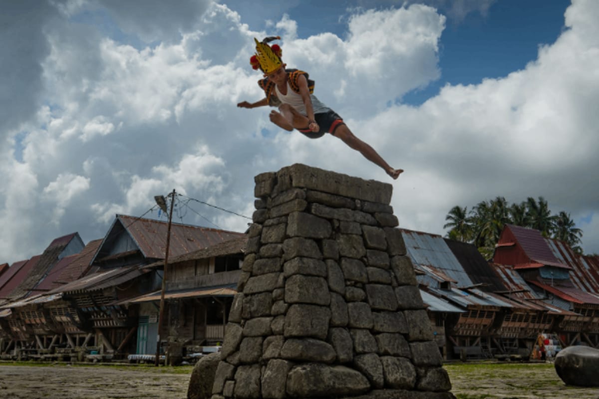 Melompat : Seorang pemuda Nias melompati batu setinggi dua meter dalam tradisi Fahombo Batu di Nias Selatan sebagai simbol kedewasaan dan keberanian.