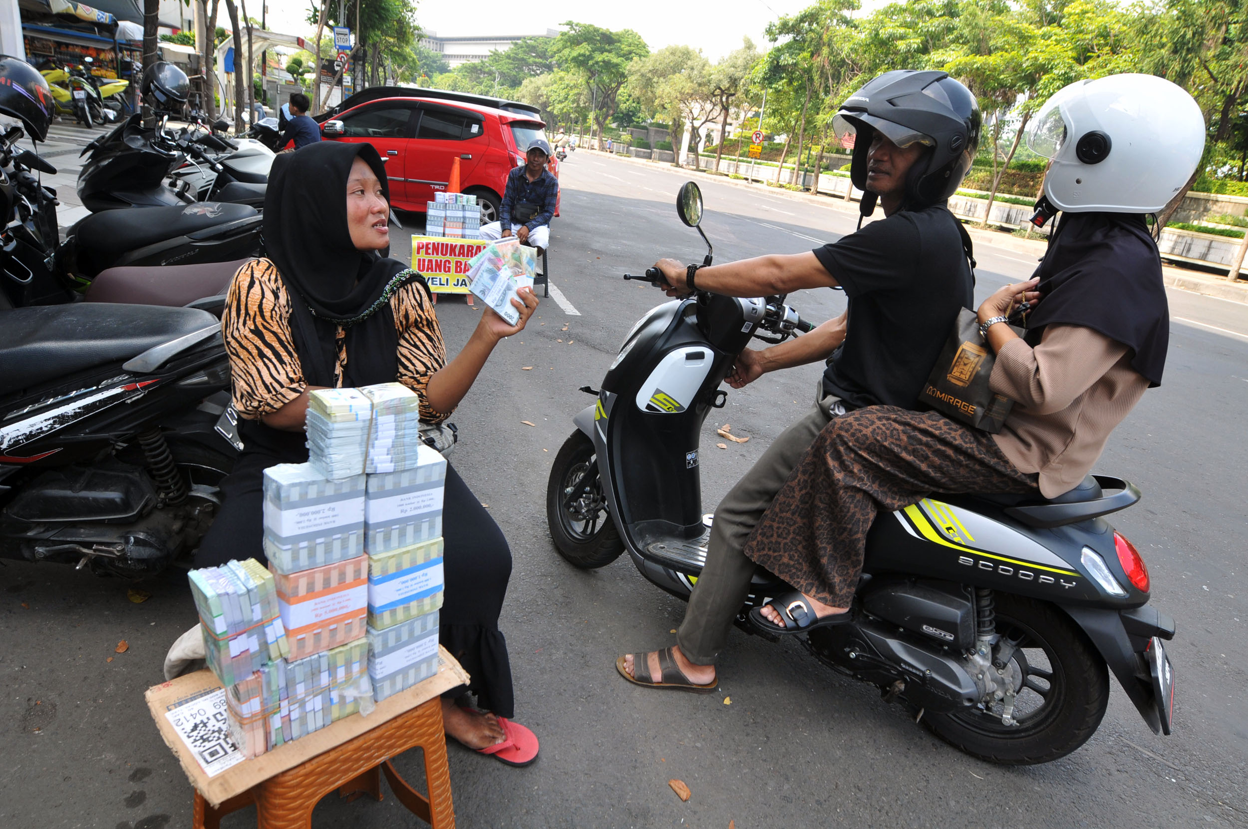 Jasa penukaran uang baru yang dilakukan masyarakat di jalan-jalan.