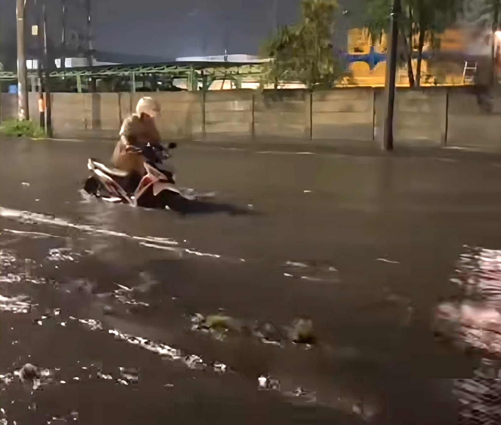 MOGOK: Salah satu pengendara saat menuntun kendaraannya usai terjebak genangan di Margomulyo dan TOW. Pemkot Surabaya akan upgrade pompa.(IST/RADAR SURABAYA)