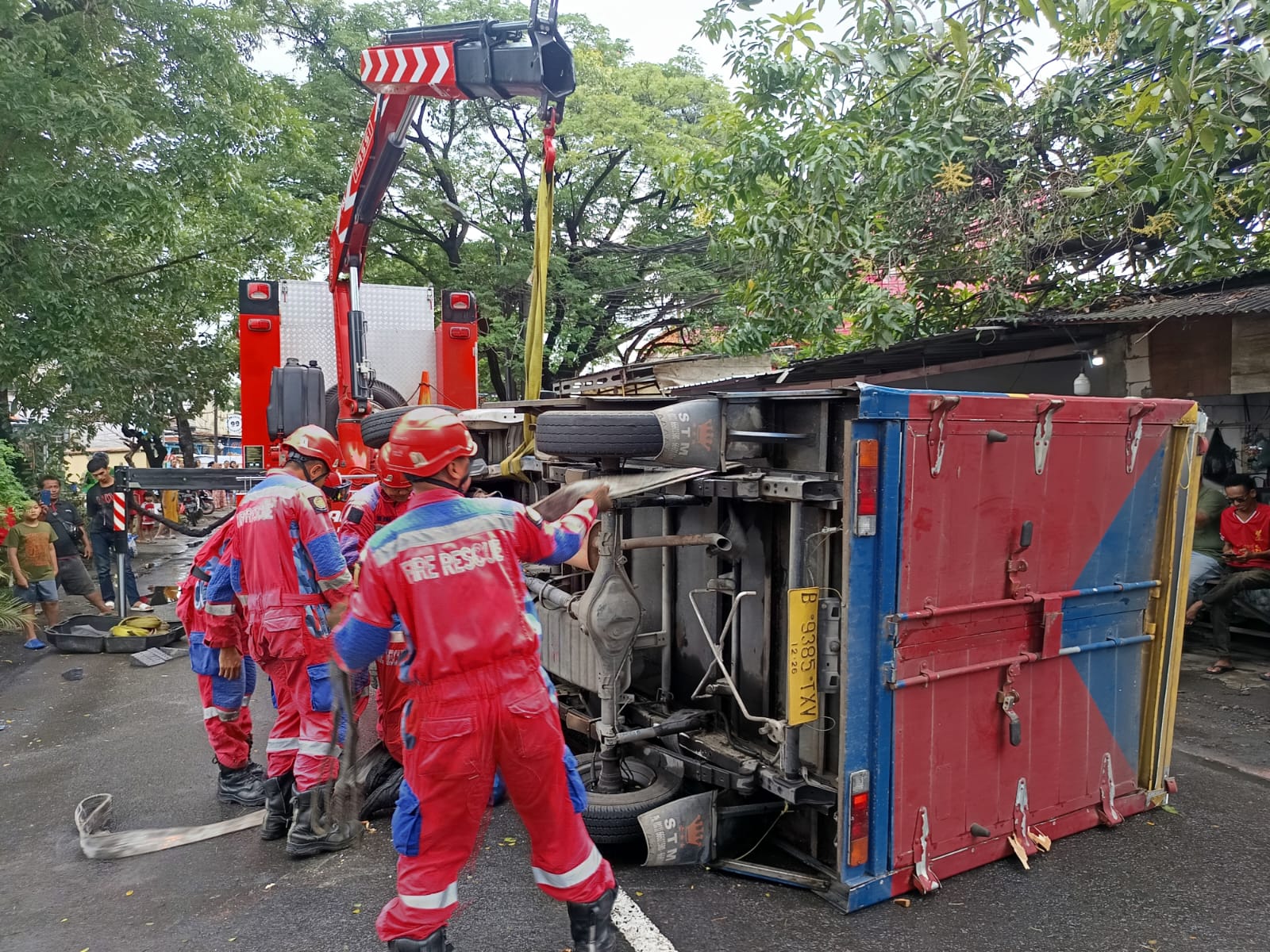 LAKA TUNGGAL : Tim Rescue DPKP Surabaya memasang tali pengikat untuk mengevakuasi truk yang terguling usai menabrak pohon di Jalan Menur Pumpungan, Surabaya, Senin (16/2). (IST/RADAR SURABAYA)