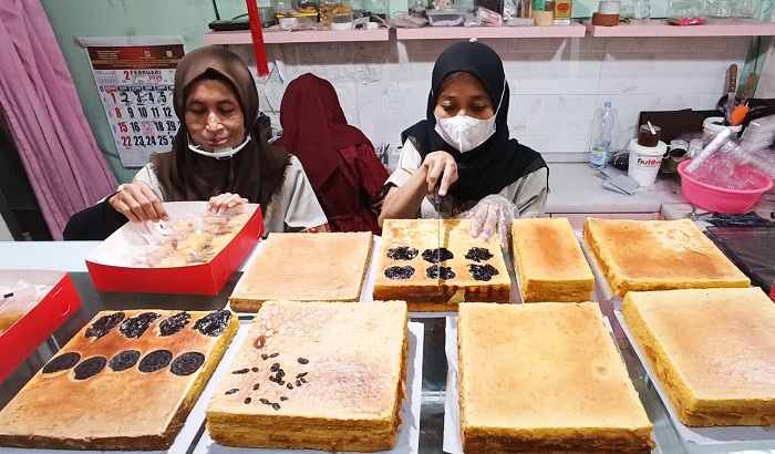 LAPIS LEGIT: Sejumlah pekerja menyiapkan kue lapis legit pesanan pelanggan, yang disajikan dalam perayaan Imlek, di toko kue Layer Speech Surabaya, Sukomanunggal, Selasa (17/2).