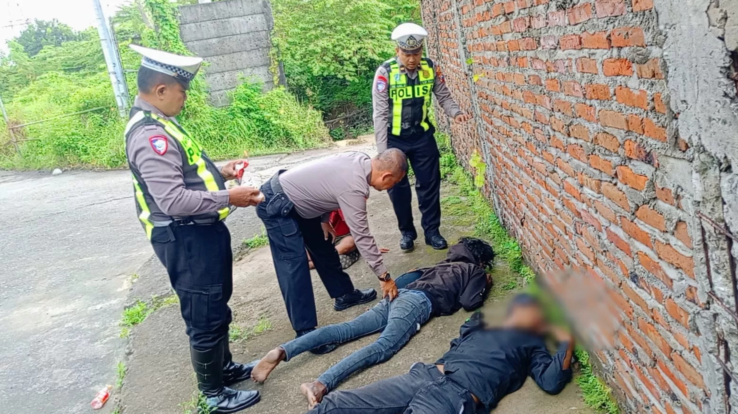 Anggota Polsek Driyorejo saat mendatangi tiga pemuda yang diduga mabuk arak Bali di pinggir jalan Perumahan Patria Bambe, Kecamatan Driyorejo, Gresik.