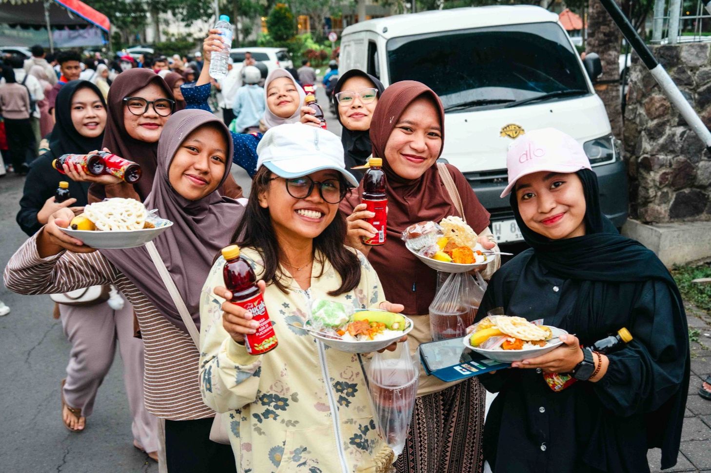 BAHAGIA: Sejumlah mahasiswi Unesa berwajah Bahagia setelah mendapatkan takjil gratis dari kampus mereka yang dipusatkan di depan gerbang Kampus 2 Lidah Wetan, Surabaya.  