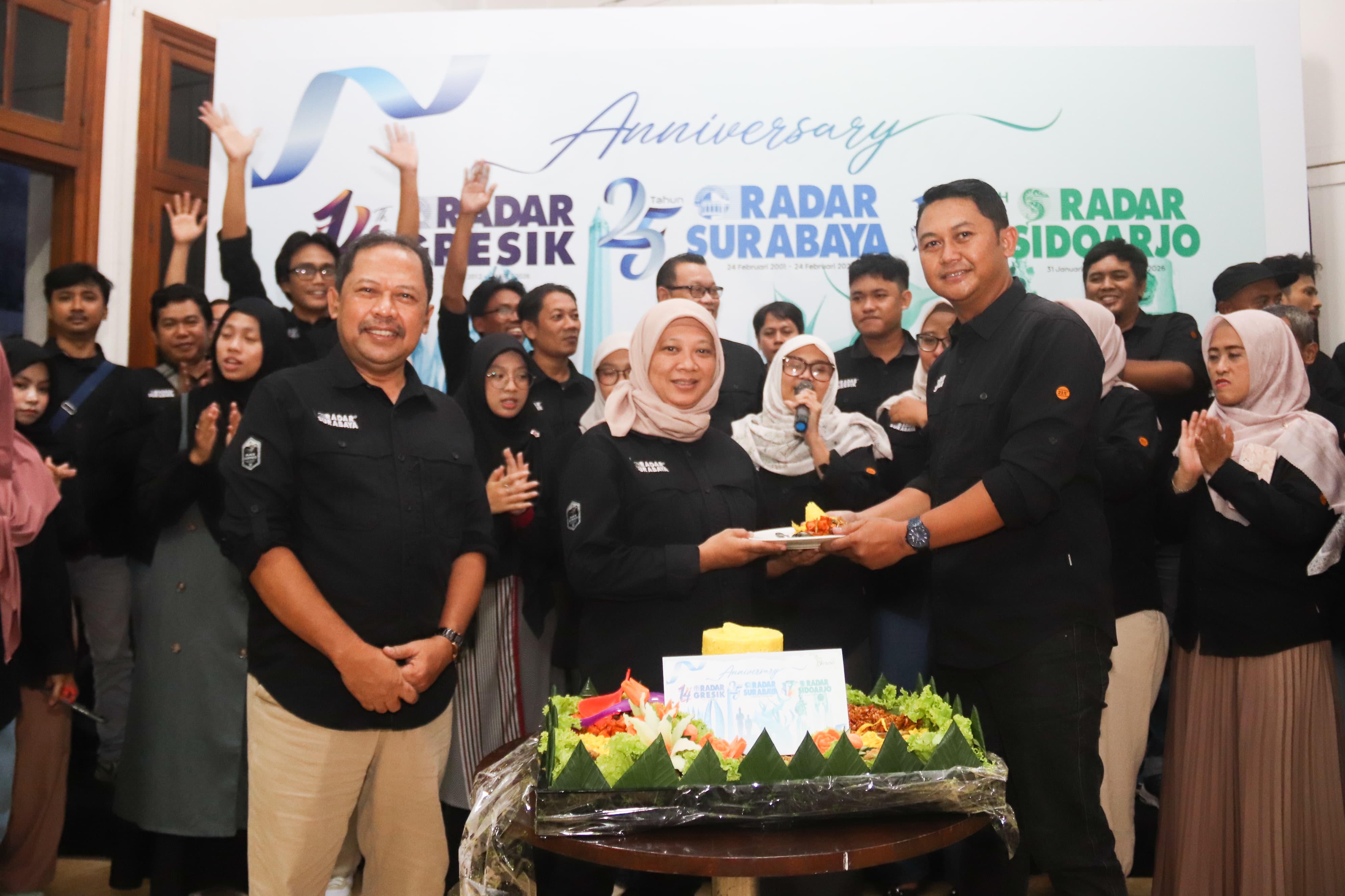 KOMPAK: Pimred Radar Surabaya Vega Dwi Arista (kanan) memberikan potongan tumpeng kepada Manajer Iklan Radar Surabaya Lainin Nadziroh  disaksikan Direktur Radar Surabaya Lilik Widyantoro (kiri).