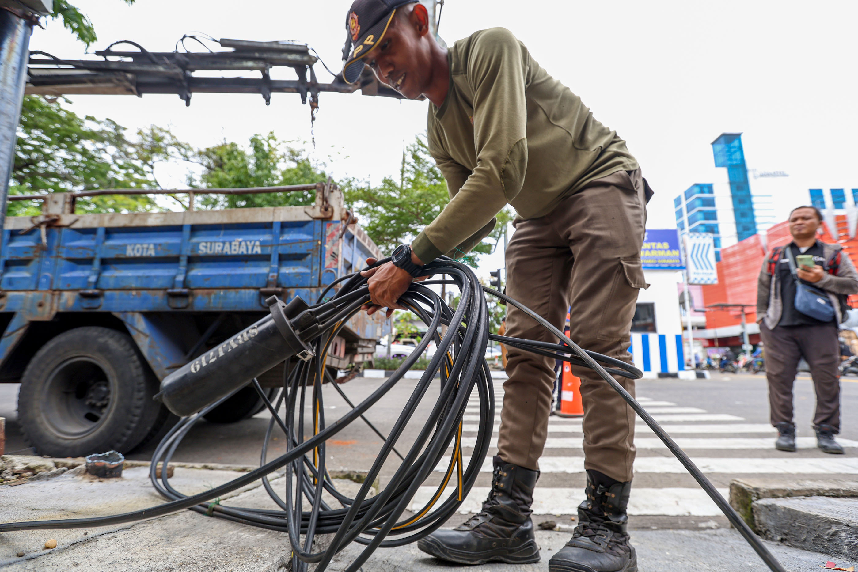 Tim gabungan Pemkot Surabaya saat menertibkan kabel fiber optik dan tiang provider yang melanggar aturan.
