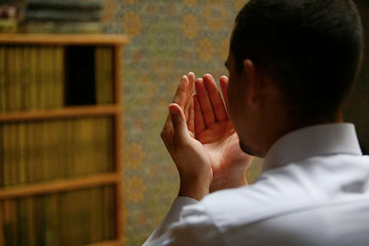  Khusyuk : Seorang umat Islam menengadahkan tangan saat memanjatkan doa di bulan Ramadan, memohon ampunan dan keberkahan di waktu yang diyakini mustajab.