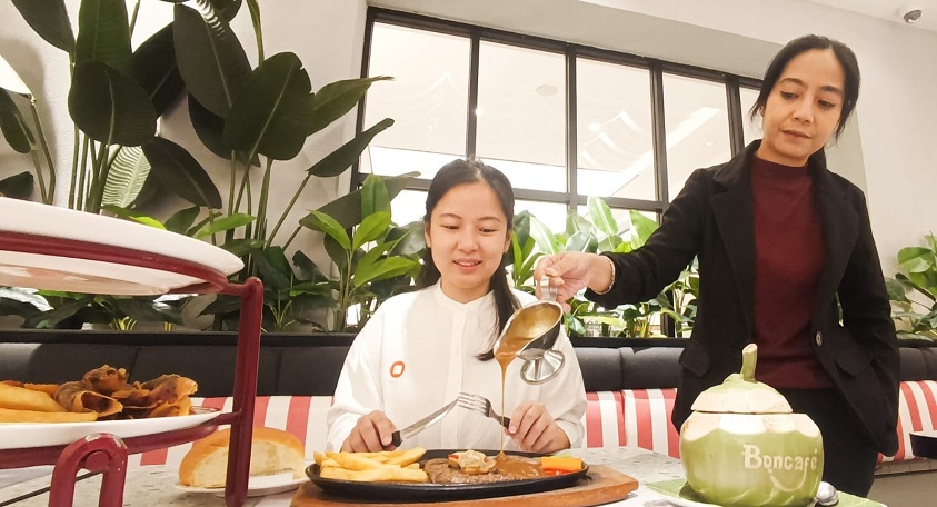 STEAK ALA SURABAYA: Seorang pengunjung menikmati menu tenderloin steak yang disajikan, dan dituangkan browns sauce secara langsung di atas hot plate, di Boncafe Gubeng, Surabaya, Kamis (26/2).  