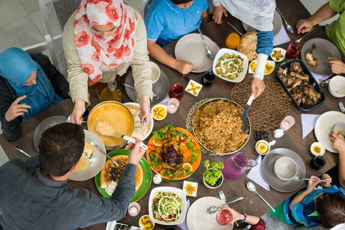 Hangat : Suasana kebersamaan keluarga saat menyantap hidangan berbuka puasa di meja makan, momen sederhana yang mempererat silaturahmi dan kebersamaan.