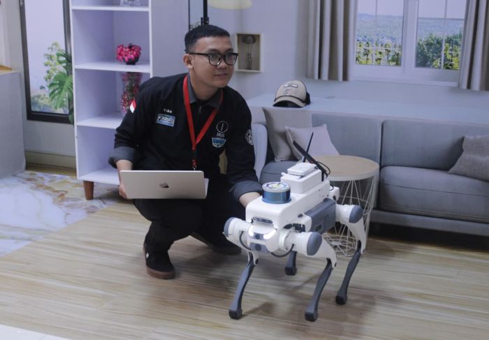 KOMPAK: Perwakilan pengembang RoboDog ITS Yuke Brilliant Hestiavin saat mempersiapkan RoboDog untuk demonstrasi pengendalian jarak jauh di Surabaya.