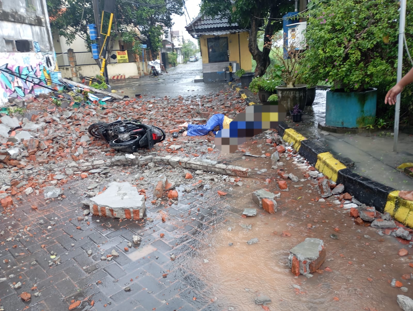 SELAMAT: Korban pengendara motor sesaat setelah tertimpa tembok bangunan yang roboh di Kebraon Indah Permai, Surabaya. (MAHRUS/RADAR SURABAYA)