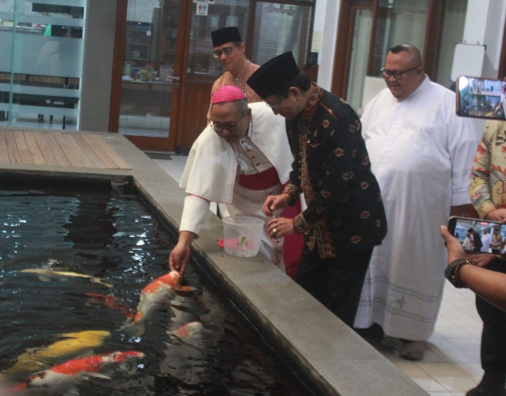 Menag Nasaruddin Umar bersama Monsinyur Agustinus Tri Budi Utomo saat memberikan makan ikan di kolam gereja Katedral Surabaya, Jumat (6/3).