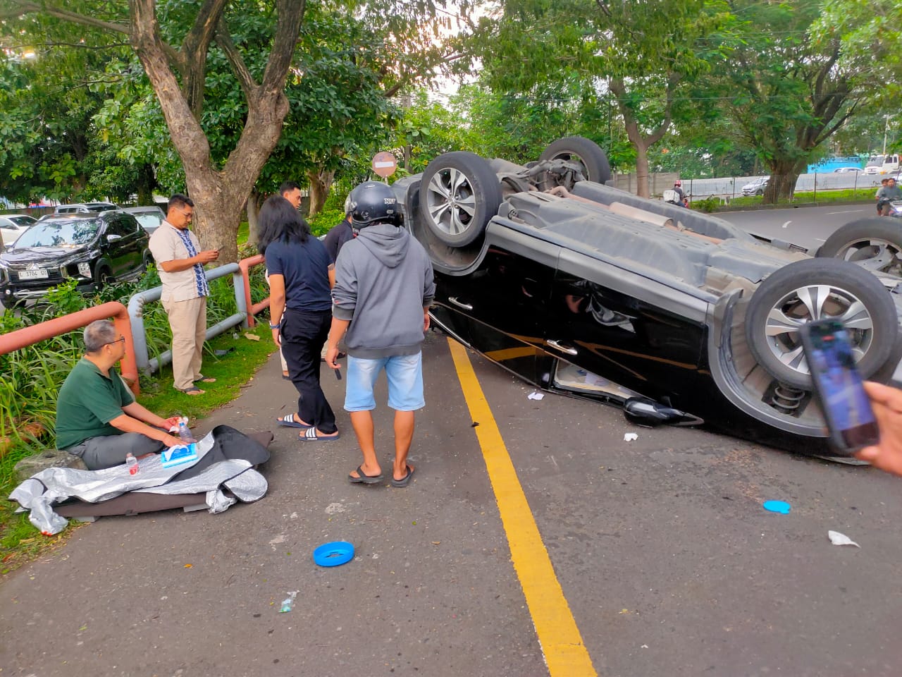 SELAMAT: Sebuah mobil terbalik di exit tol Masjid Al Akbar, Surabaya, usai tabrak pembatas jalan. (IST/RADAR SURABAYA)  
