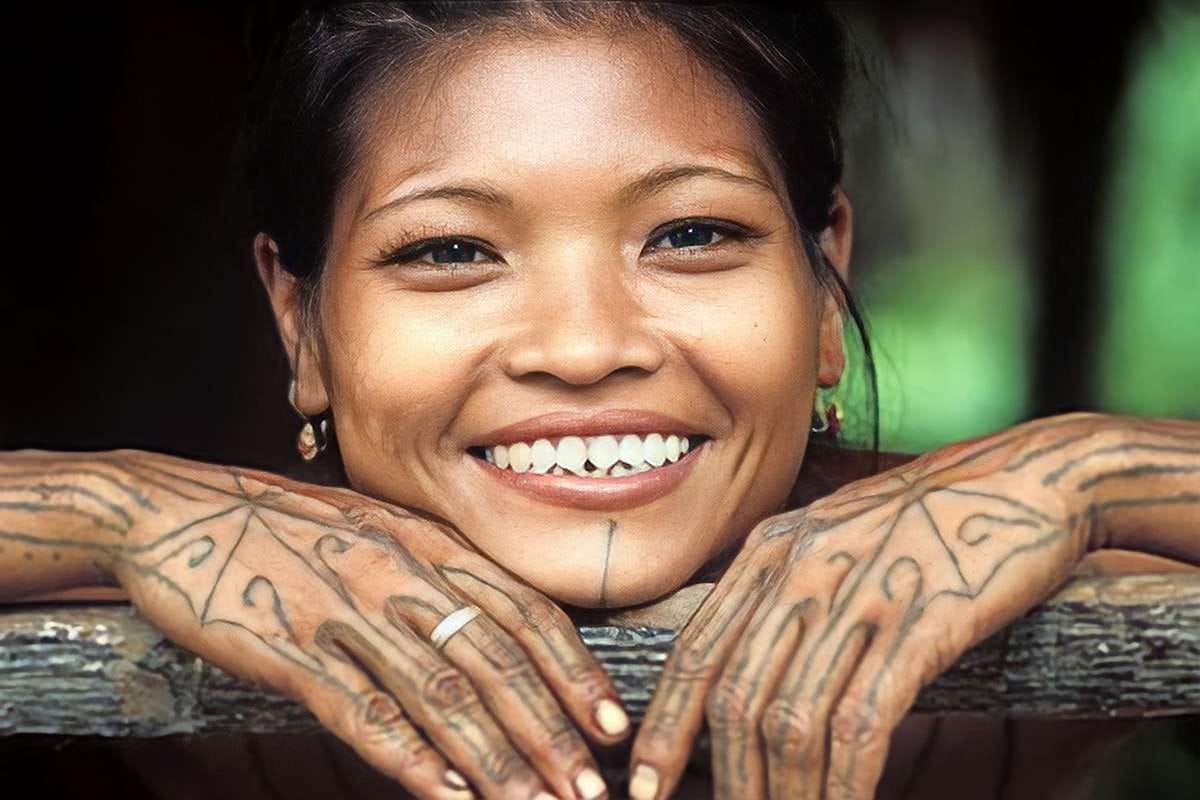 Budaya : Seorang perempuan dari Suku Mentawai memperlihatkan gigi yang diruncingkan serta tato tradisional di tubuhnya.