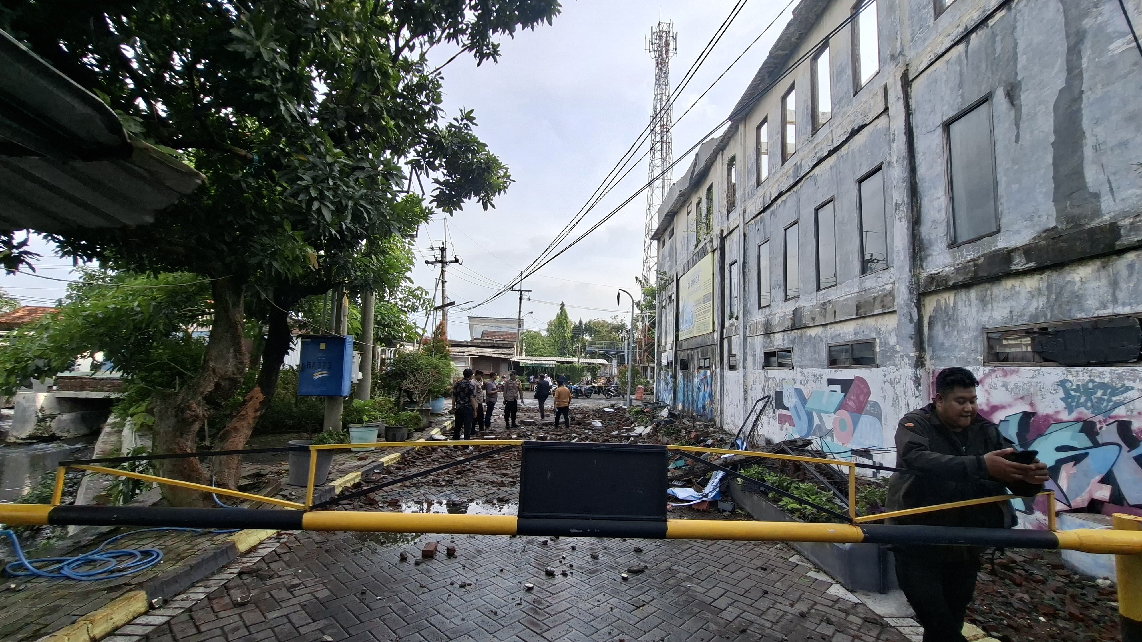 PENYELIDIKAN: Polisi turun tangan menyelidiki kasus pengendara motor meninggal tertimpa tembok di Jalan Kebraon Indah Permai, Surabaya.(MAHRUS/RADAR SURABAYA)