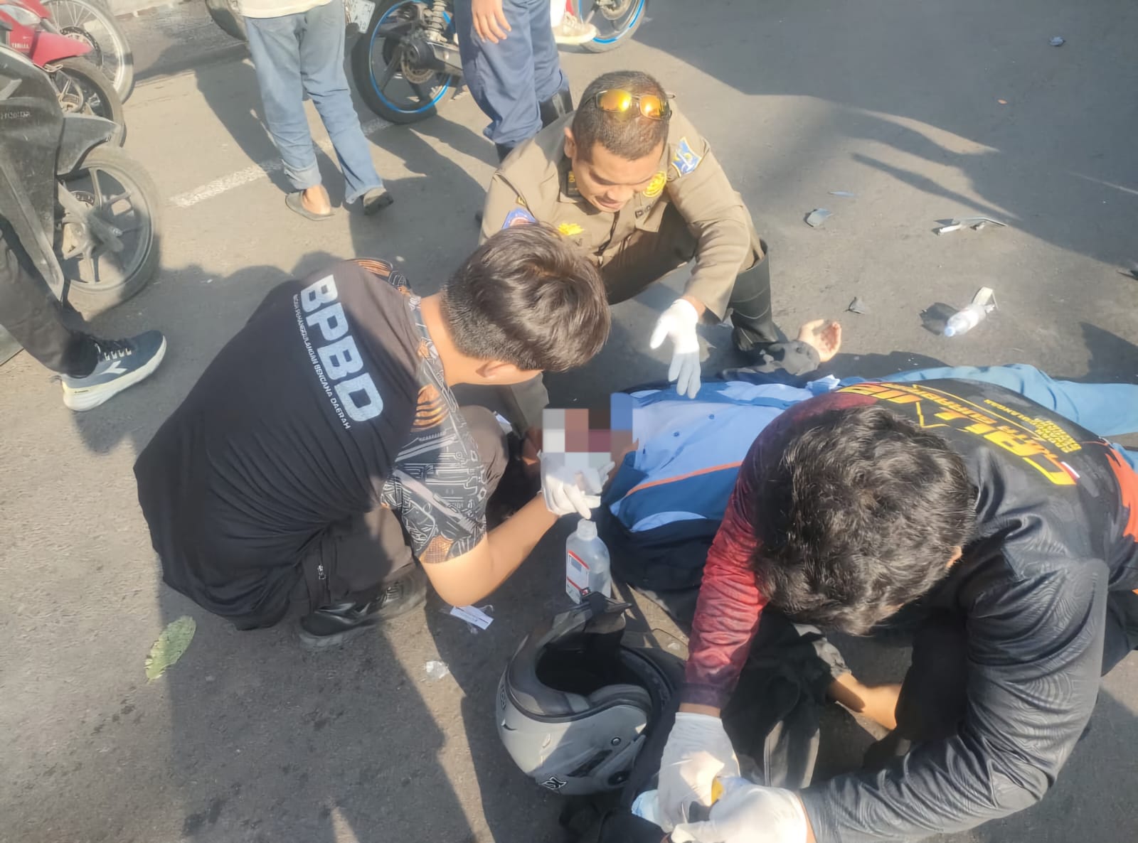 LUKA-LUKA : Tim medis dan Posko Barat memberikan penanganan medis pada korban. Pemotor ini tabrak truk dari belakang di Jalan Romokalisari, Surabaya, Senin (9/3).(IST/RADAR SURABAYA)