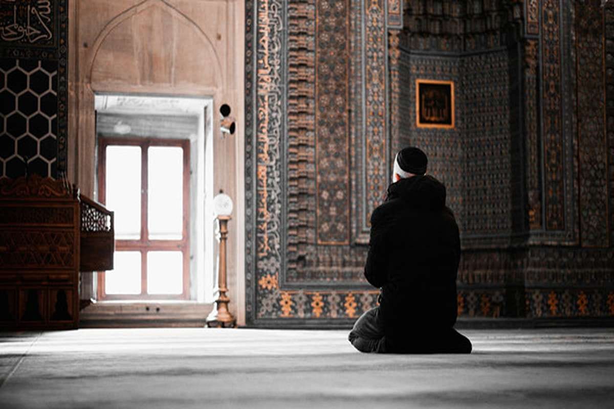 Khusyuk : Seorang muslim berzikir dan berdoa di dalam masjid menjelang waktu berbuka puasa pada bulan Ramadan.