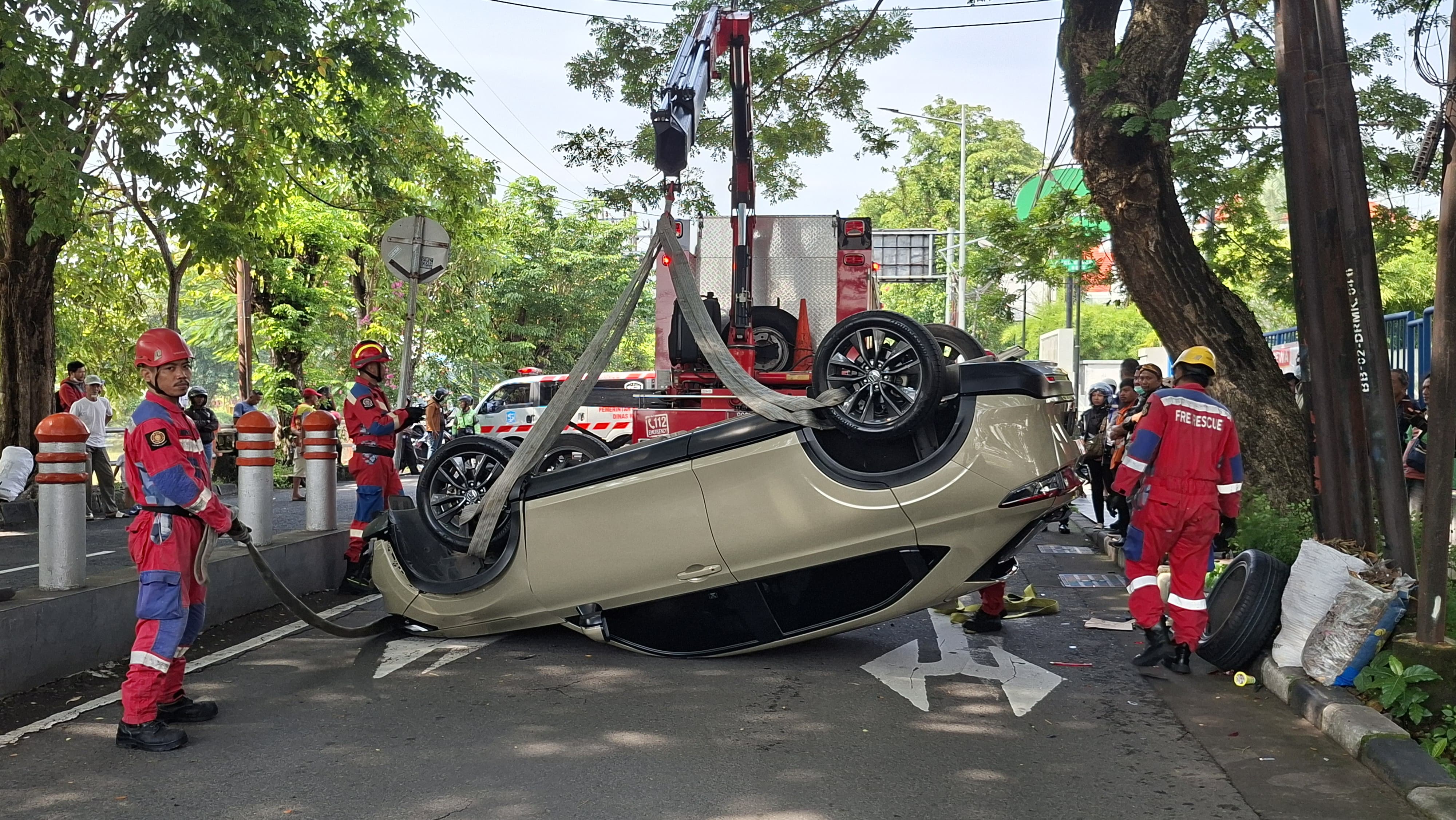 TERBALIK: Tim Rescue DPKP Surabaya mengevakuasi mobil terbalik usai menabrak pembatas di Jalan Darmo Kali, Surabaya, Selasa (10/3).