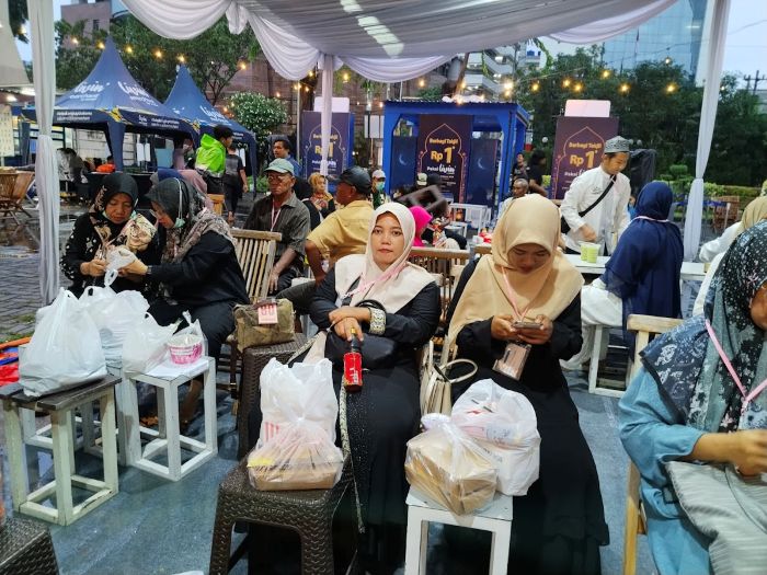 BAHAGIA: Sejumlah guru ngaji menunggu waktu berbuka setelah sebelumnya antre membeli takjil dengan voucher yang diberikan IPIP dalam rangka bakti sosial akbar, Senin (9/3).