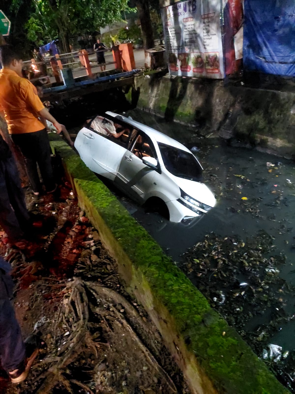 TERCEBUR: Mobil Toyota Avanza yang disopiri Yulius Malio tercebur sungai Jalan Cipta Menanggal, Surabaya, Rabu (11/3).