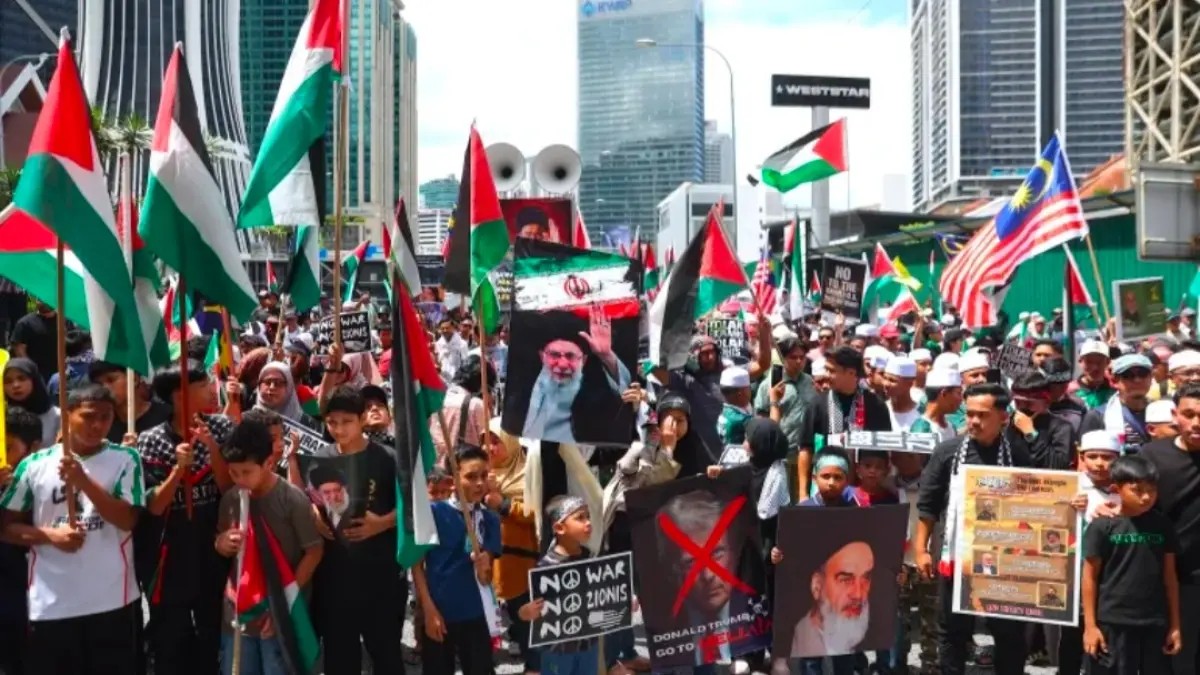 Para pengunjuk rasa membawa poster dan mengibarkan bendera Palestina saat melakukan long march menuju Kedutaan Besar Amerika Serikat dalam rangka memperingati Hari Internasional Al-Quds di Kuala Lumpur, Malaysia. Foto: Fazry Ismail/EPA.