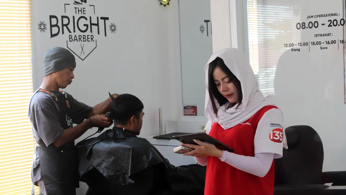 PENAMPILAN BARU: Salah satu bapak-bapak sedang mencukur rambut secara gratis di Serambi MyPertamina KM 66A Pandaan – Malang. (Abdullah Munir/Radar Surabaya)