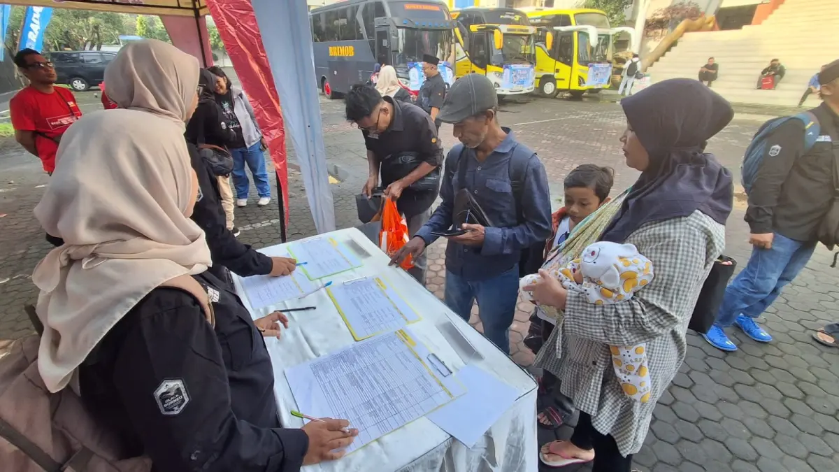Peserta Mudik Gratis Bareng Radar Surabaya 2026 melakukan daftar ulang sebelum diberangkatkan pada Selasa pagi (17/3). (DIMAS MAHENDRA/RADAR SURABAYA)