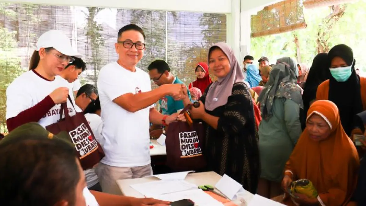 PASAR MURAH: Rektor Ubaya, Benny Lianto menyerahkan npaket sembako murah kepada masyarakat, dalam kegiatan Pasar Murah yang digelar oleh Ubaya. (IST)