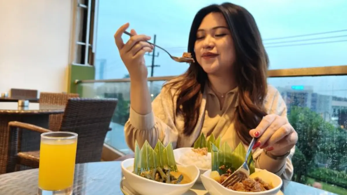 RENDANG AUTENTIK: Salah satu penikmat kuliner khas Minang, Mozayana, mencoba kreasi kuliner rendang yang dikenal autentik, di salah satu hotel di Surabaya. (ANDY SATRIA/RADAR SURABAYA)