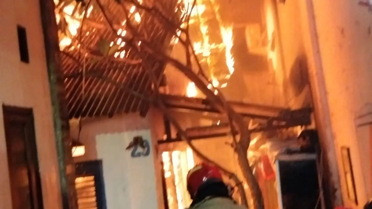 MEMBARA : Petugas DPKP Surabaya berupaya memadamkan kobaran api yang membakar rumah di Jalan Ketandan Lama II, Surabaya, Sabtu (21/3). Ini membuat Jalan Tunjungan ditutup. (IST/RADAR SURABAYA)