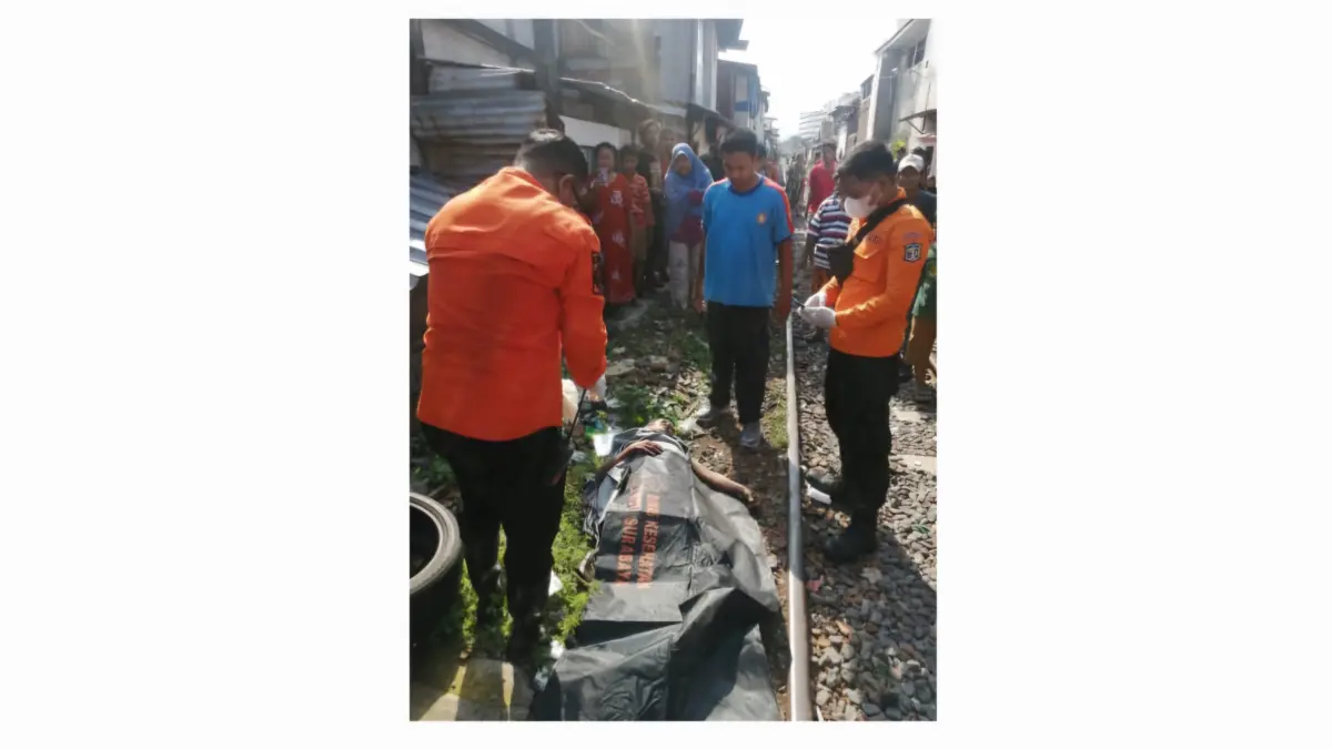 SELAMAT: Korban Roepijono saat mendapat pertolongan pertama petugas usai terserempet KA dan terseret 30 meter di Perlintasan Jalan Kemayoran Baru, Surabaya.(IST/RADAR SURABAYA)