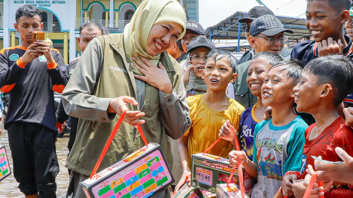 Gubernur Khofifah membagikan paket makanan kepada anak-anak korban banjir Pasuruan. (Humas Pemprov Jatim)