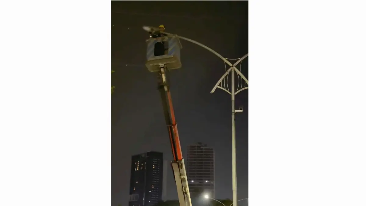 MENYALA: Petugas Dishub Surabaya saat melakukan perbaikan PJU yang mati di underpass Satelit. (IST/RADAR SURABAYA)