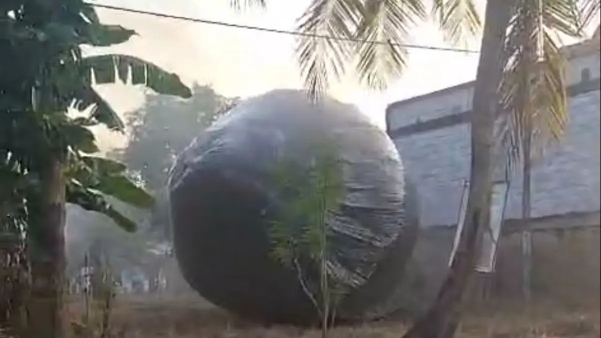 Balon udara berwarna hitam dan berukuran besar yang jatuh di permukiman warga Dusun Blingi, Palengaan, Pamekasan, Sabtu (28/3). (Kompas.com)
