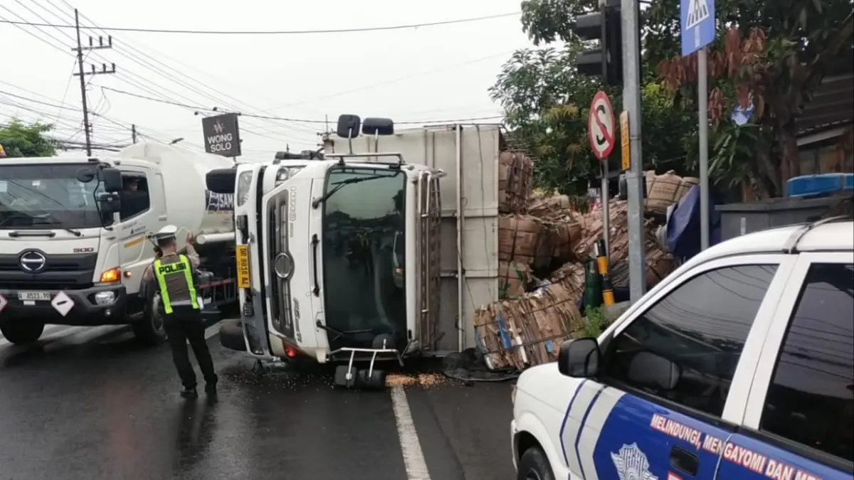 LAKA TUNGGAL: Truk bermuatan karton yang disopiri WS tergulin di Jalan Mastrip, Karangpilang Surabaya, Sabtu (28/3). (ISTIMEWA)