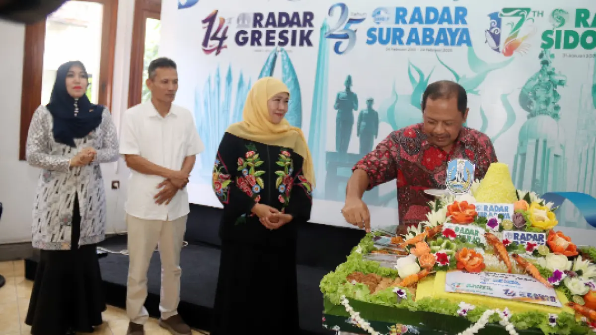 Gubernur Jatim Khofifah Indar Parawansa menyaksikan pemotongan tumpeng oleh Direktur Radar Surabaya Lilik Widyantoro saat Open House HUT Radar Surabaya Group. (ANDY SATRIA/RADAR SURABAYA) 
