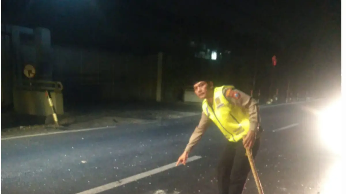 EVAKUASI : Petugas mengevakuasi jenazah pengendara motor yang meninggal dunia usai tabrakan dengan truk kontainer di Jalan Mastrip, Karangpilag, Surabaya, Jumat (3/4).(IST/RADAR SURABAYA)