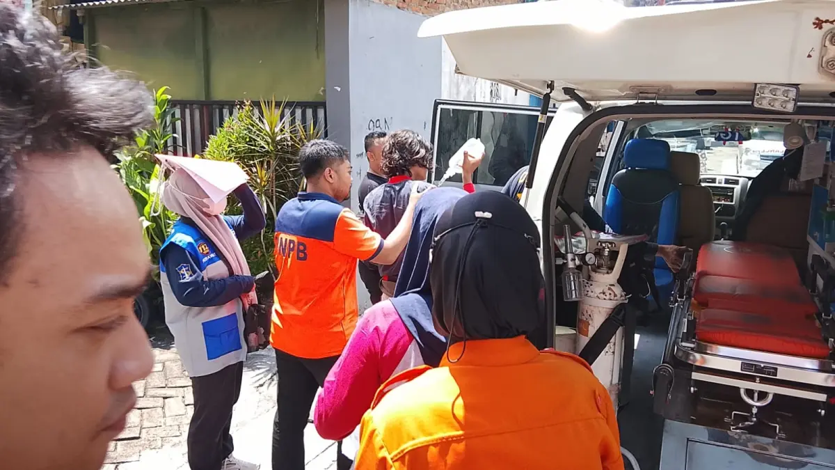 PENANGANAN: Petugas BPBD dan Tim Gerak Cepat membantu penanganan medis kepada korban keracunan massal di Jalan Sido Kapasan X, Simokerto Surabaya, Sabtu (4/4). (ISTIMEWA)