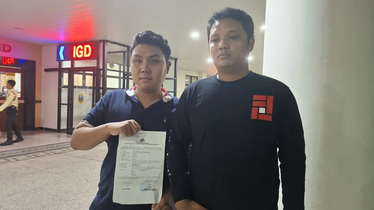 JALUR HUKUM: Pimpinan gerakan forjustice Purnama (kanan) usai membuat laporan di Polrestabes Surabaya. Ia dilempar batu dan dikeroyok saat ikut sosialisasi parkir digital di Jalan Manyar Kertoarjo, Surabaya. (M MAHRUS/RADAR SURABAYA)