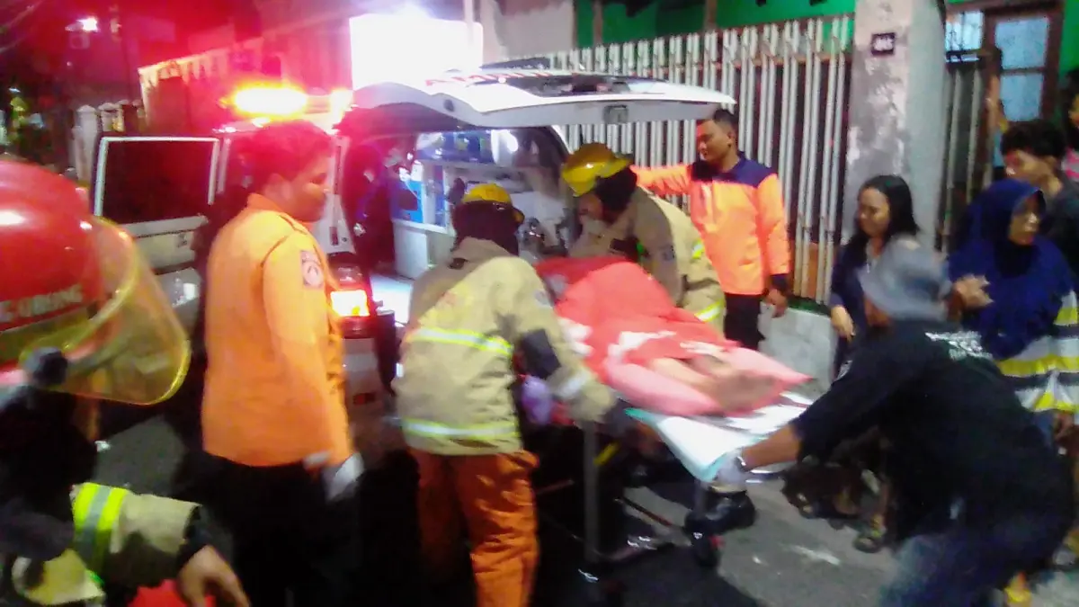 EVAKUASI: Petugas DPKP dan BPBD mengevakuasi korban luka akibat kebakaran di rumah Jalan Babadan Bubutan Surabaya, Rabu (8/4) pagi. (ISTIMEWA)