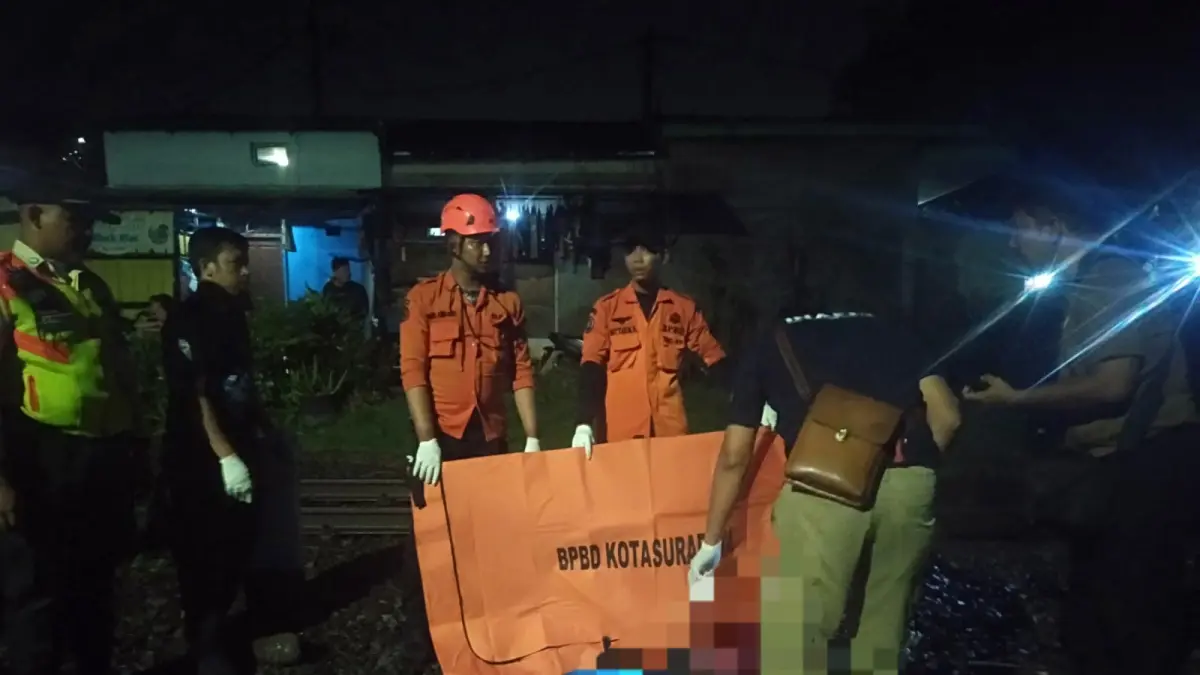 LOKASI: Jasad Mrs X saat hendak dievakuasi usai tertabrak KA di perlintasan Jalan Ngagel Tirto Surabaya. (IST/RADAR SURABAYA)