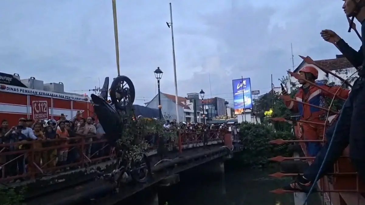 EVAKUASI: Puluhan orang menyaksikan evakuasi motor milik jambret yang tercebur ke Sungai Kalimas, Surabaya. Motor berhasil dievakuasi petugas DPKP Surabaya.(MAHRUS/RADAR SURABAYA)