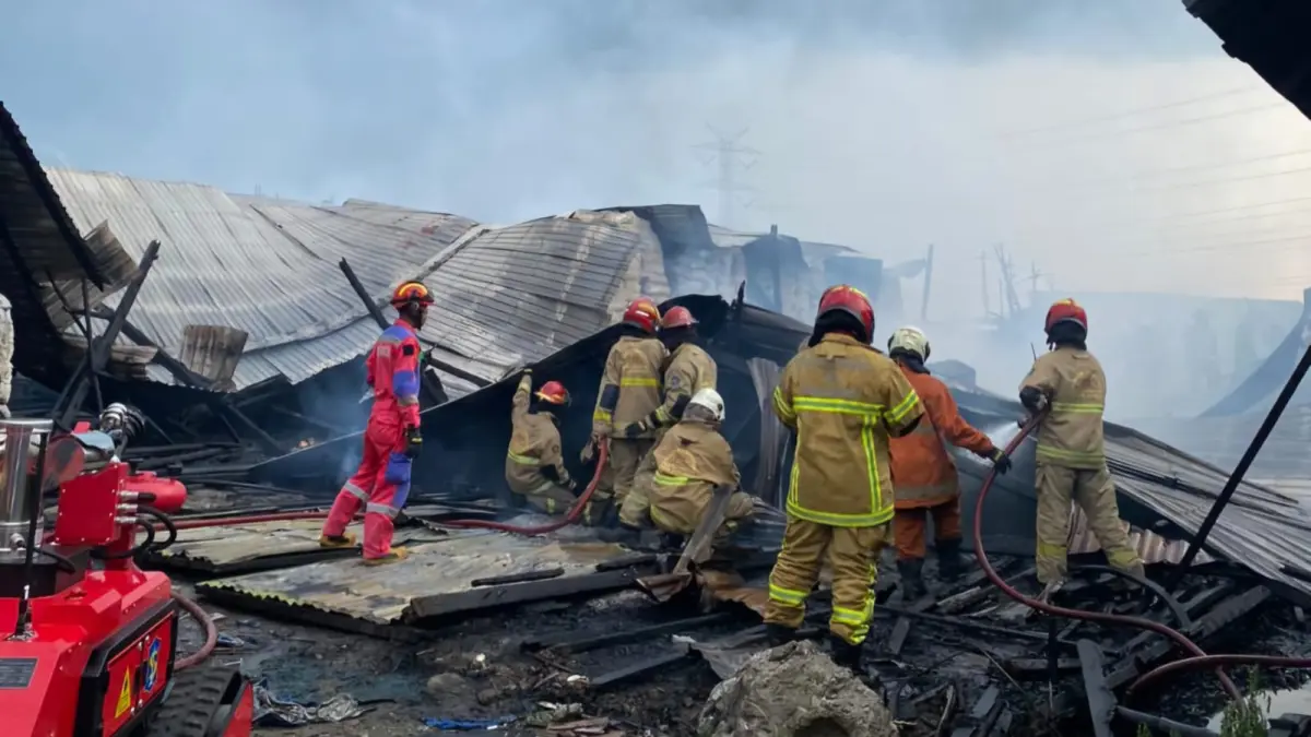 BERUPAYA: Petugas DPKP Surabaya saat melakukan pemadaman di gudang Jalan Jawar, Surabaya. (IST/RADAR SURABAYA)

