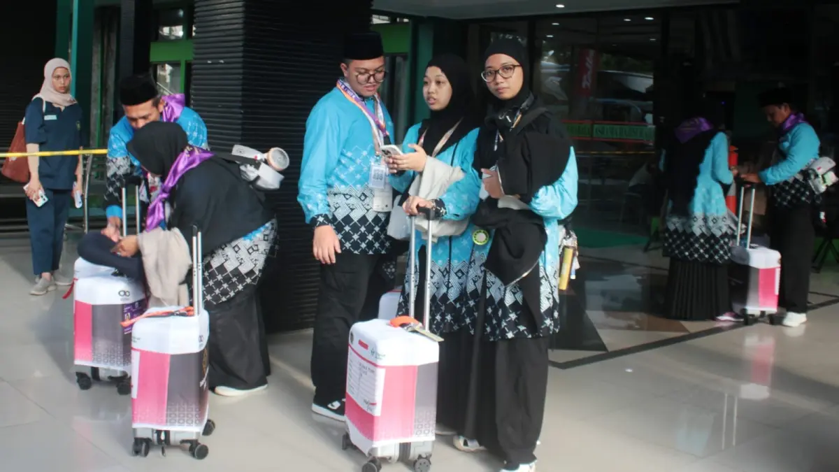 Jemaah haji kloter 18 berada di Bir Ali Asrama Haji Surabaya saat hendak naik bus yang mengantarkan ke Bandara Juanda sebelum terbang ke Madinah, Minggu (26/4). (Rahmat Sudrajat/Radar Surabaya)