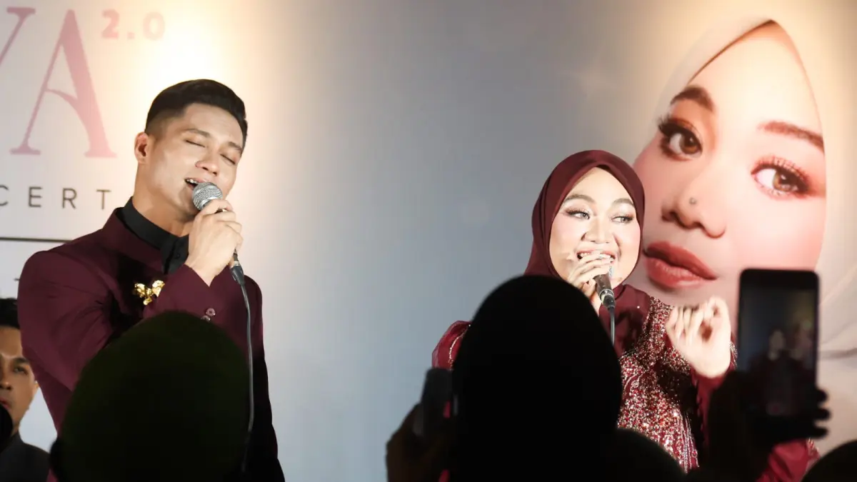 Fadhilah Intan (kanan) menggandeng penyanyi asal Malaysia, Daniesh Suffian dalam konser yang bertajuk Seraya 2.0 di Balai Pemuda, Surabaya, Minggu (26/4) malam. (ANDY SATRIA/RADAR SURABAYA) 