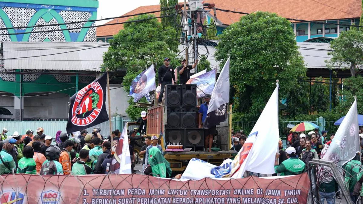 BERORASI: Ratusan ojol dan taksol saat demo dan berorasi di depan Kantor DPRD Jatim. Mereka menuntut kejelasan regulasi dan perlindungan. (MUS PURMADANI/ RADAR SURABAYA)