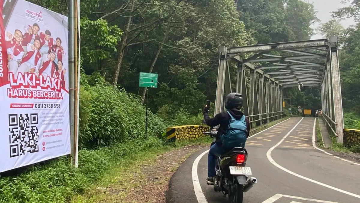 Baliho peringatan dan layanan hotline yang dipasang di dekat Jembatan Cangar. (Kompas.com)