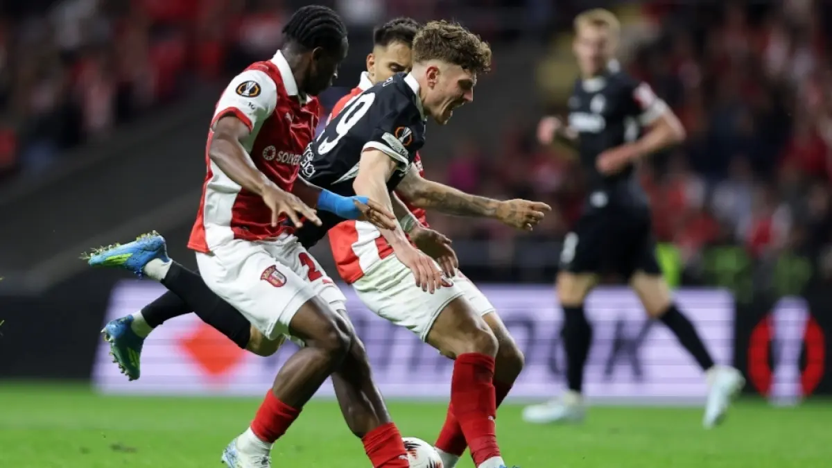 Philipp Treu dari Freiburg jatuh di antara pemain Braga Mario Dorgeles, bek kiri, dan Rodrigo Zalazar saat pertandingan sepak bola semifinal, leg pertama, Liga Europa antara SC Braga dan Freiburg di Braga, Portugal, Kamis, 30 April 2026. | Foto: AP/Miguel Angelo Pereira