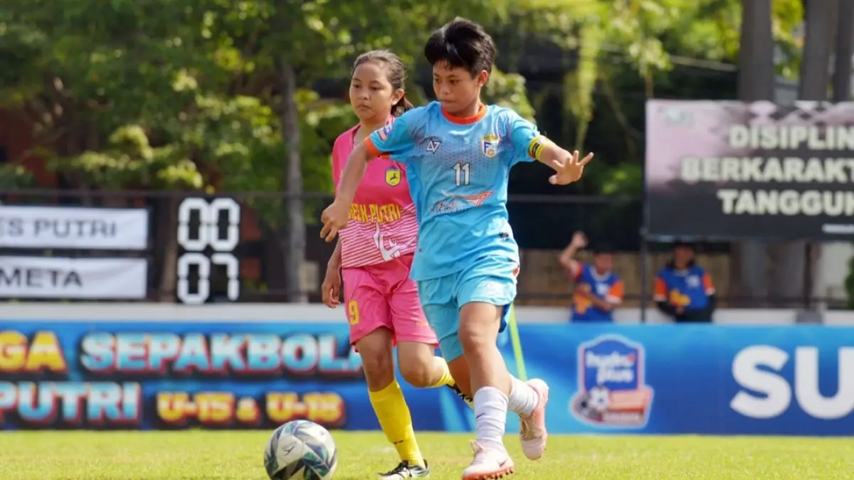 Pemain Putri Meta (biru) dihadang pemain dari Persegres Putri, dalam lanjutan Kompetisi sepak bola putri U-15 di Lapangan Bogowonto, Surabaya, Sabtu (9/5). (Andy Satria/Radar Surabaya) 